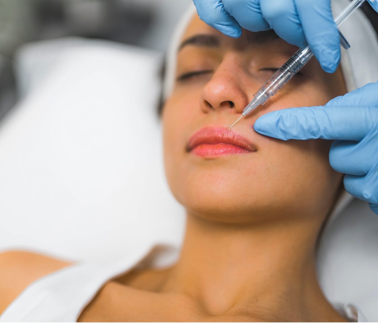 Extreme closeup indoor shot showing lip filler procedure at SPA and wellness salon. A licensed healthcare professional performing dermal filler on her caucasian female patient. High quality photo | Aesthetic Center of Richmond Dermatology in Medical spa in Glen Allen, VA